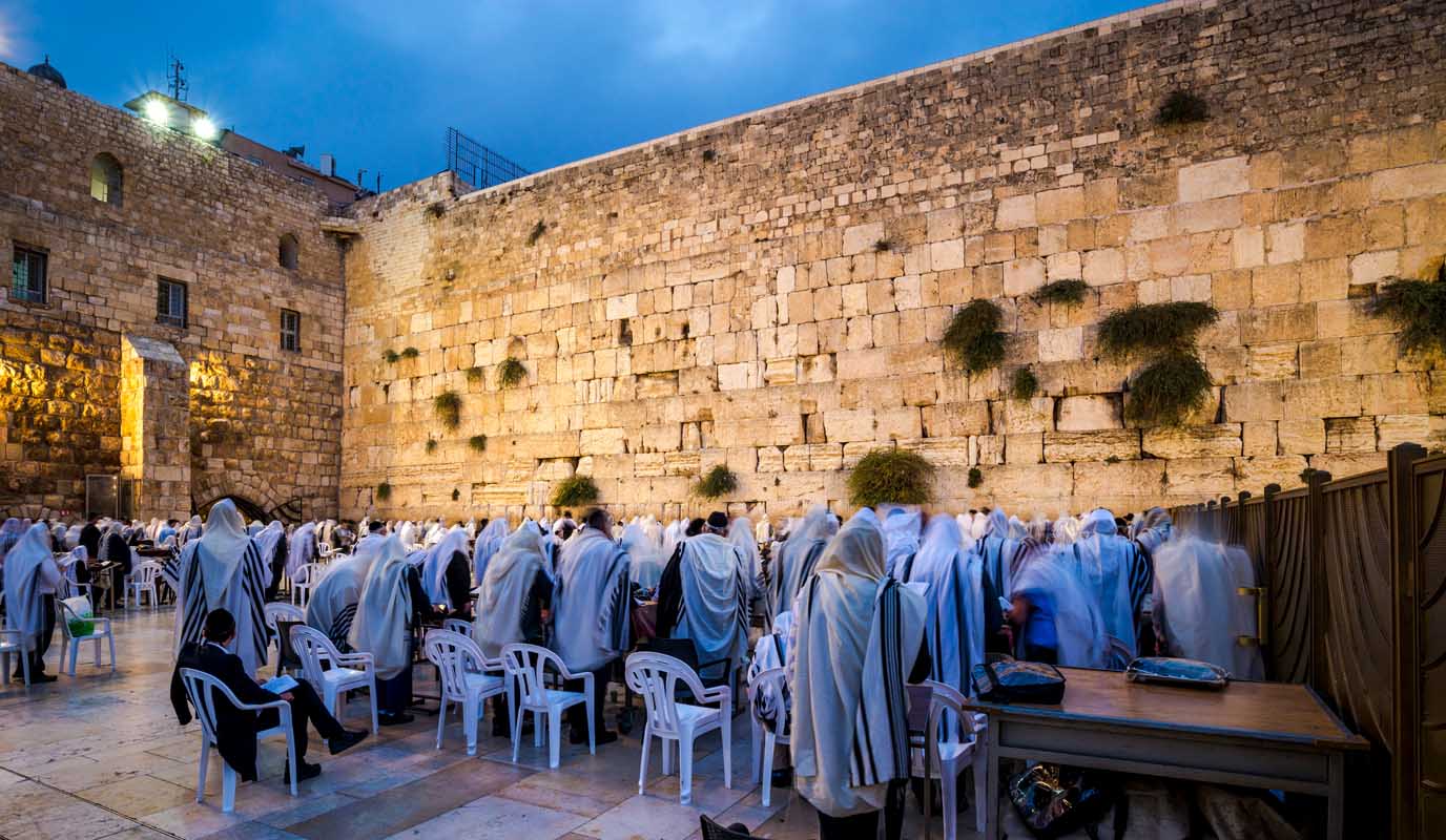 Orthodox Jewish men in prayer shawls gathered before dawn for morning prayer at the Western Wall, Jerusalem