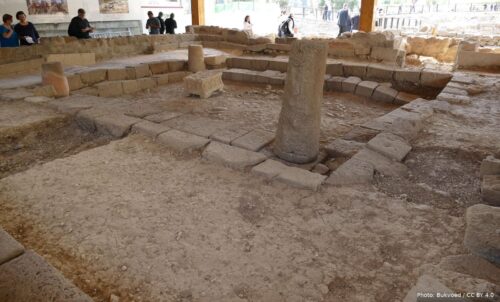 The excavated synagogue at Magdala on the Sea of Galilee, with its stone benches, a standing column and a carved stone block at the centre of the hall